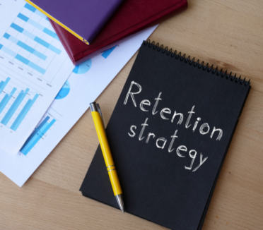 A notebook with the words "Retention Strategy" written on the cover.