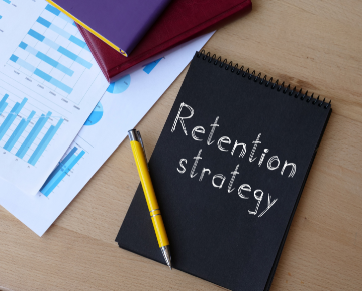A notebook with the words "Retention Strategy" written on the cover.