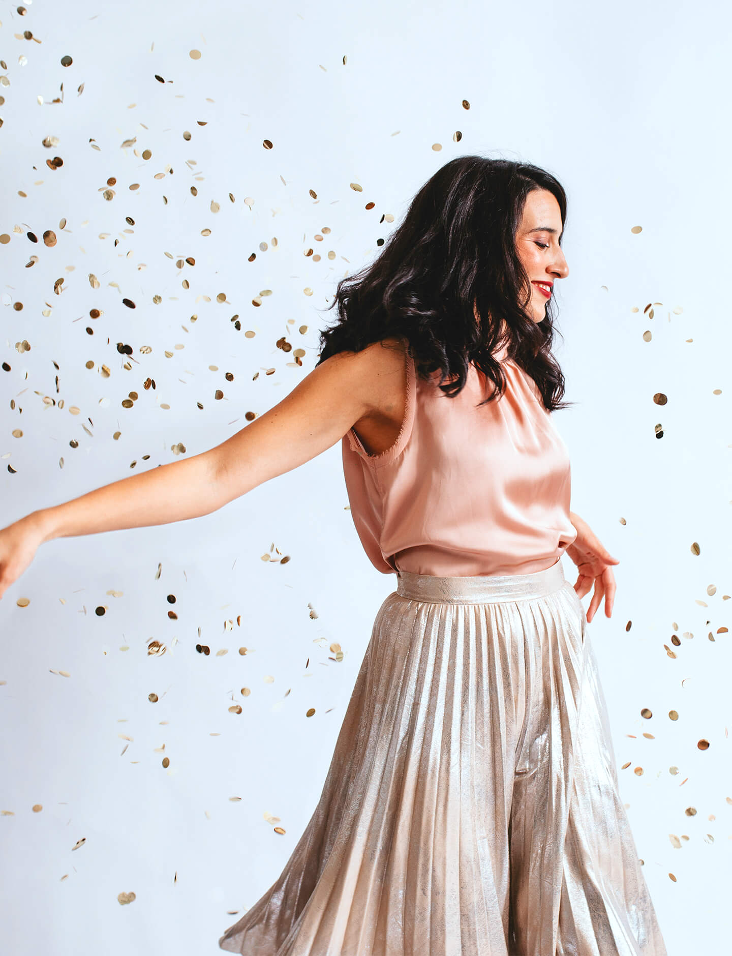 woman dancing in confetti floating in the air