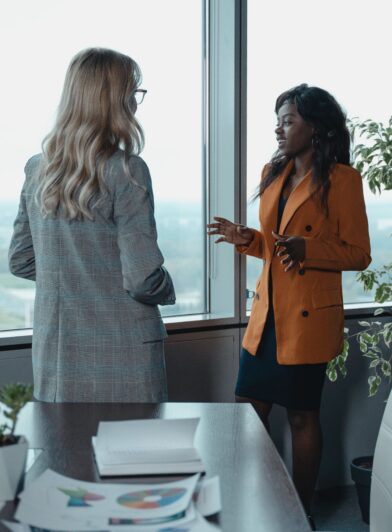 Two professionals standing in a conference room talking